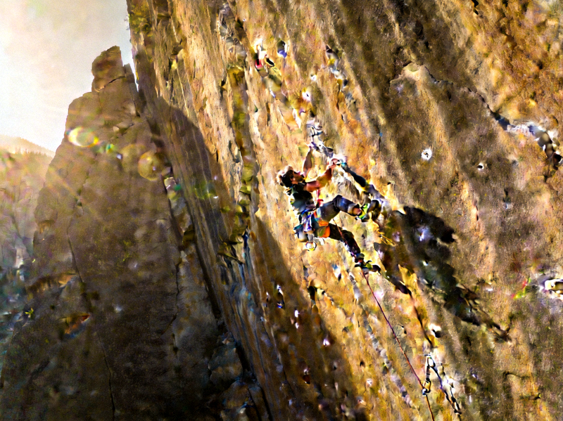 极限攀岩场景，攀岩者在陡峭岩壁上