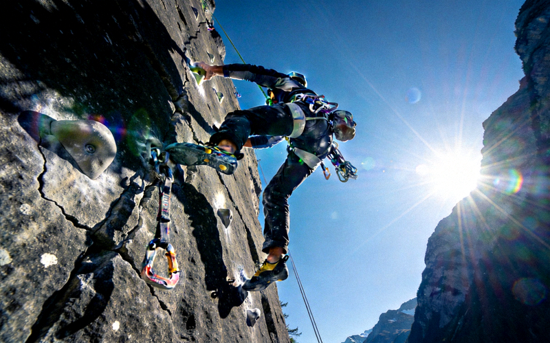 极限攀岩挑战场景，攀岩者在陡峭岩壁上